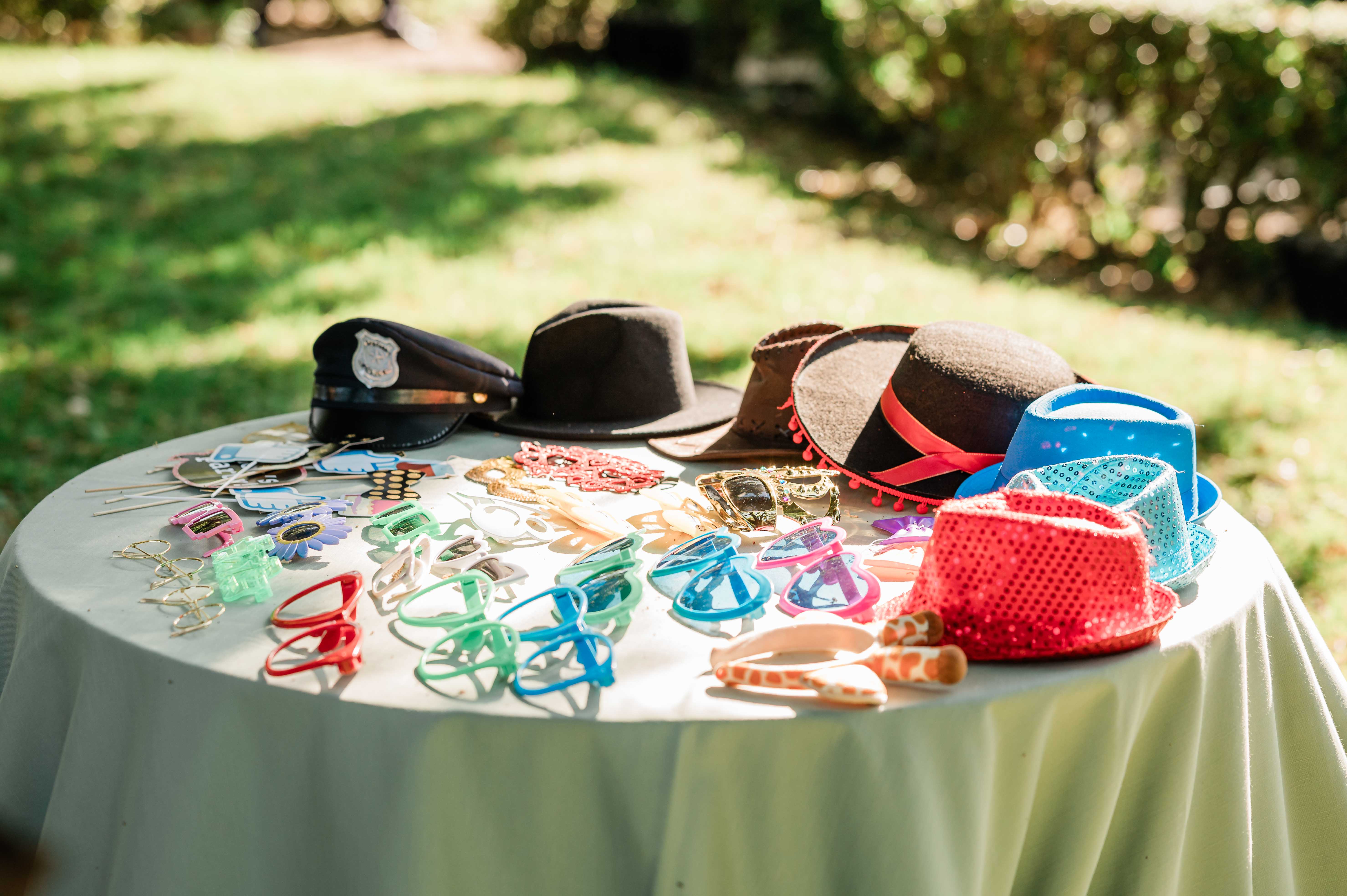 Tavolo dei gadget photo booth con cappelli, occhiali colorati, cornici e accessori per matrimoni